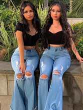 Vaqueros de mezclilla desgastados, deshilachados y con parte inferior acampanada